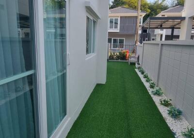 Side yard with artificial grass and modern fencing