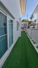 Side yard with artificial grass and modern fencing