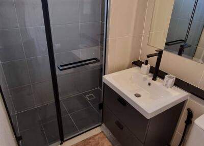 Modern bathroom with shower, vanity, and toilet