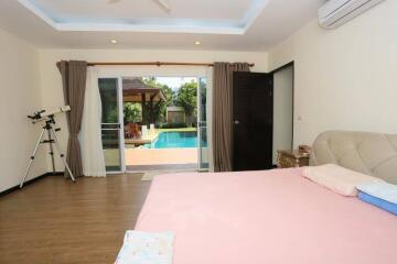 Bedroom with a large glass door leading to a swimming pool