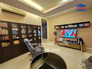 Cozy living room with bookshelves, TV, and comfortable seating