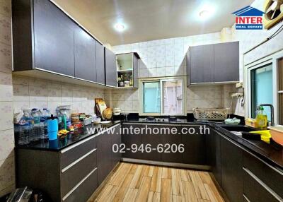 Modern kitchen with dark cabinets and wooden flooring