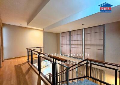 Modern hallway with wooden floor and glass railing