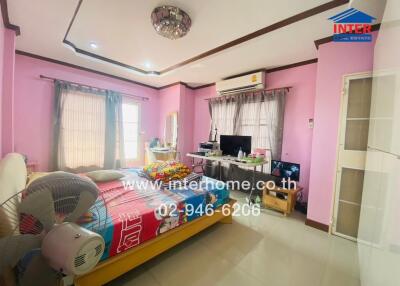 Spacious bedroom with pink walls, a double bed, and multiple windows.