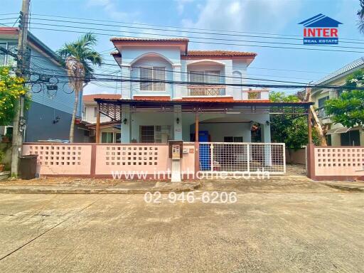 Two-story house exterior with a gated front yard.