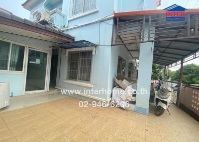 Front of the house with a porch, windows, and a scooter parked.