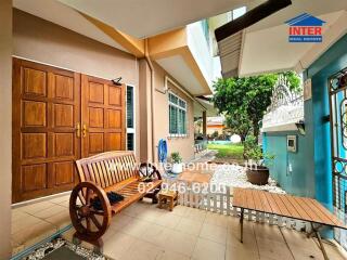 Outdoor seating area of a property with wooden bench and garden view