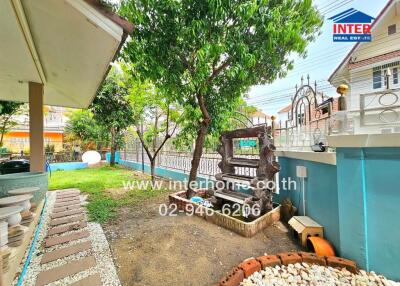 Outdoor yard with green foliage, a small garden bed, and a decorative log display at a residential property