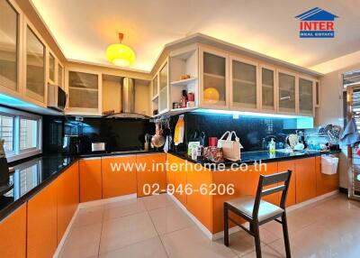 Modern kitchen with orange cabinets and black countertops