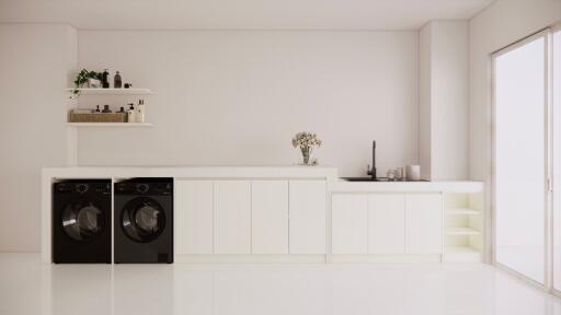 Modern laundry room with washing machines and white cabinetry