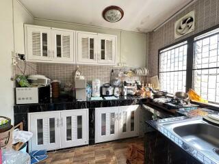 Modern kitchen with white cabinets and various appliances