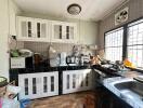 Modern kitchen with white cabinets and various appliances