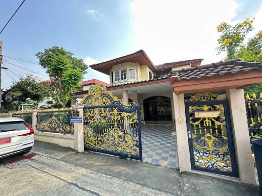 Front view of a residential house with a decorated gate and driveway