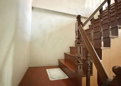 Stairs with wooden banister leading to a higher floor