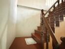 Stairs with wooden banister leading to a higher floor