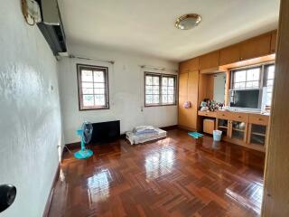 Bedroom with wooden flooring, built-in storage, and natural light