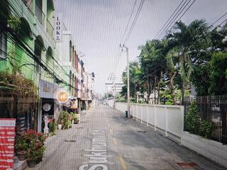 Street view of neighborhood with shops and greenery