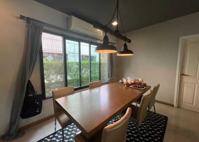 Dining room with large wooden table and hanging lamps