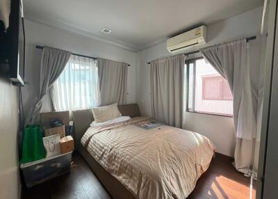 Bright bedroom with double bed, air conditioning, and storage