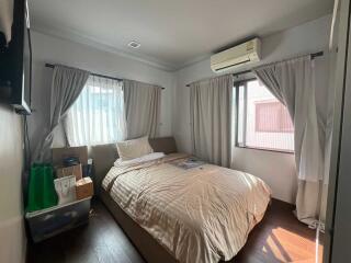 Bright bedroom with double bed, air conditioning, and storage