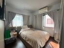 Bright bedroom with double bed, air conditioning, and storage