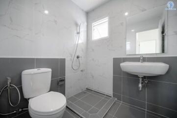 Modern bathroom with shower area, toilet, and sink