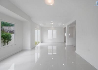 Spacious, well-lit living area with large windows and glossy floor tiles