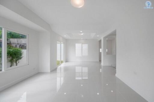 Spacious, well-lit living area with large windows and glossy floor tiles