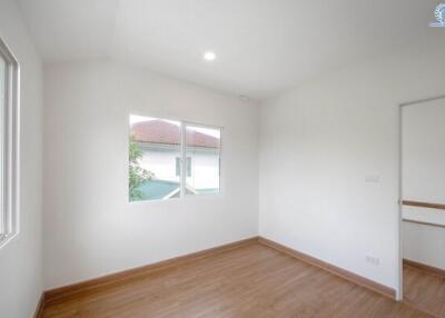 Empty bedroom with wooden flooring and two windows