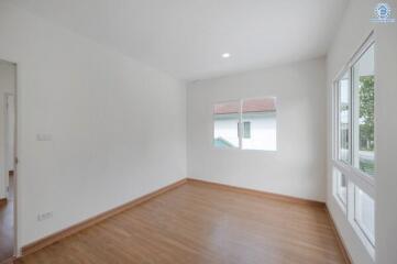 empty bedroom with wooden floor and white walls