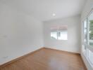 empty bedroom with wooden floor and white walls