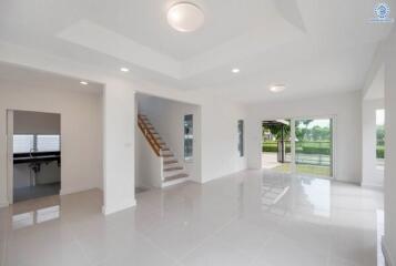 Spacious living area with large windows and staircase