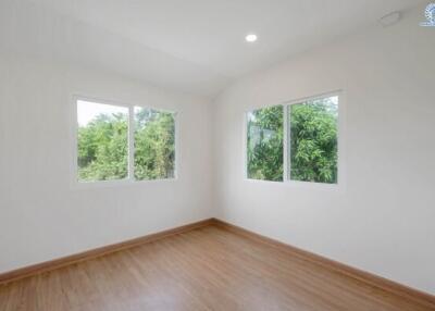 Empty bedroom with wooden floor and large windows