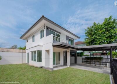 Two-story house with a well-maintained yard and a carport