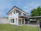 Two-story house with a well-maintained yard and a carport