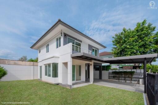 Two-story house with a well-maintained yard and a carport