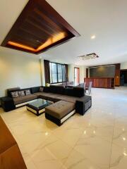 Modern living room with sectional sofa, coffee table, and dining area