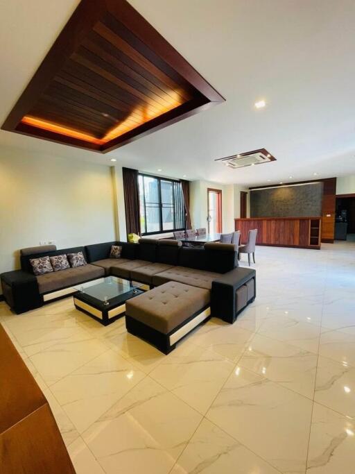 Modern living room with sectional sofa, coffee table, and dining area