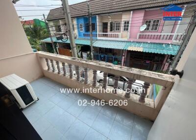 Balcony with view of neighboring houses and air conditioning unit