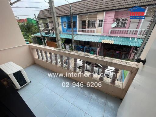 Balcony with view of neighboring houses and air conditioning unit