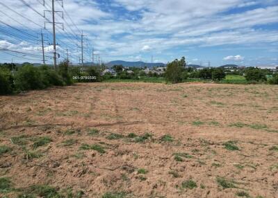 Vacant plot of land with power lines and scenic background