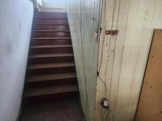 A wooden stairway with a handrail and wall paneling