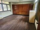 Spacious bedroom with wooden floor and built-in cabinets