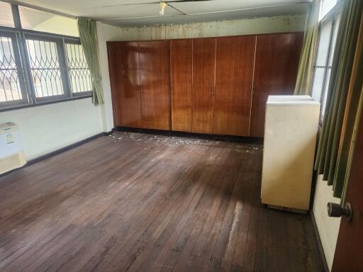 Spacious bedroom with wooden floor and built-in cabinets