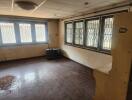 Empty living room with ceiling tiles and barred windows