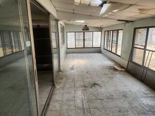 Interior of a rundown and empty room with large windows