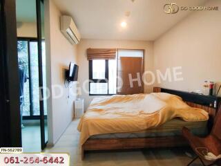 Spacious bedroom with a bed, television, air conditioning, and a window.