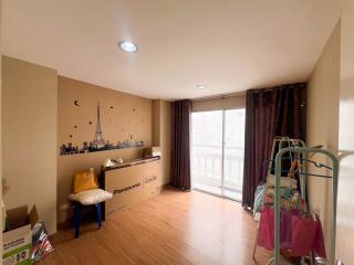 Bedroom with large window, balcony access, and storage boxes