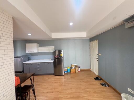 Modern kitchen area with grey cabinets and wooden flooring