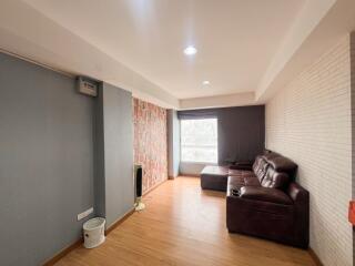 Modern living room with large windows, sofa, and wooden flooring